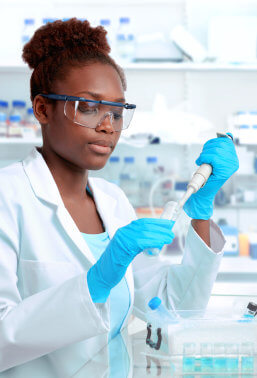 a picture of young pharmacist mixing chemicals on the laboratory.