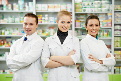 Cheerful pharmacist women and men standing in pharmacy drugstore